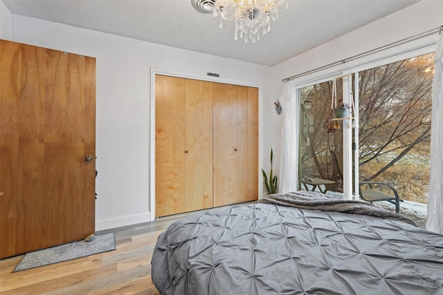 bedroom featuring a textured ceiling, a closet, and light hardwood / wood-style floors