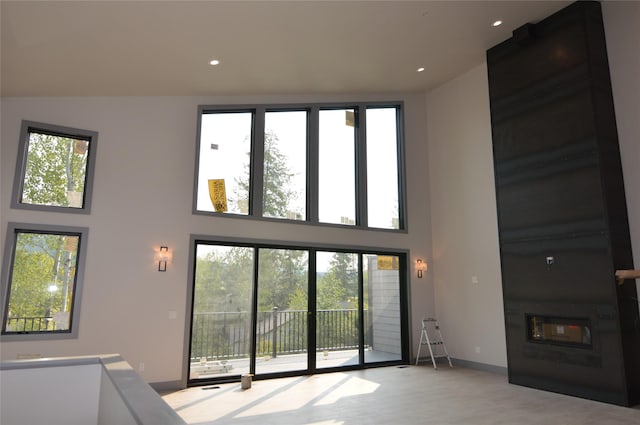 unfurnished living room with a large fireplace and a towering ceiling