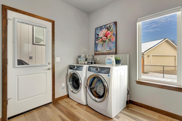 laundry room featuring separate washer and dryer and light hardwood / wood-style flooring