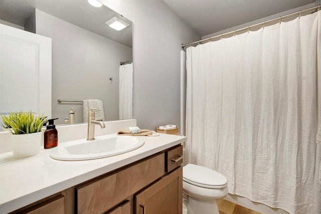 bathroom featuring toilet, hardwood / wood-style flooring, and vanity