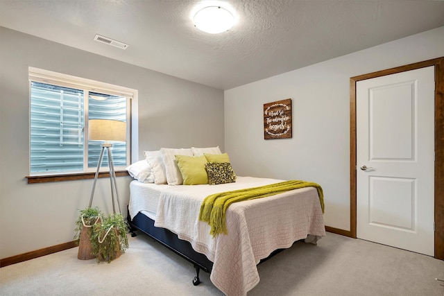 carpeted bedroom featuring a textured ceiling