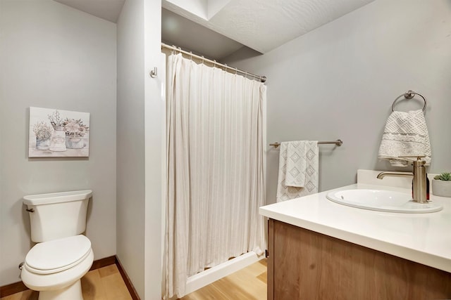 bathroom with toilet, hardwood / wood-style flooring, curtained shower, and vanity