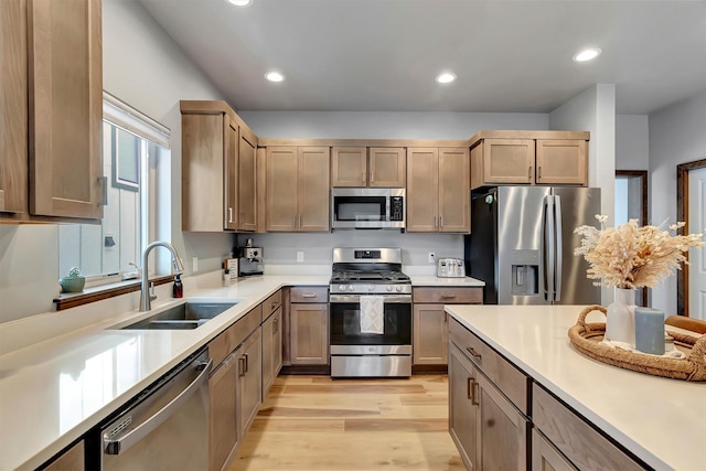 kitchen featuring sink, light wood-type flooring, and appliances with stainless steel finishes