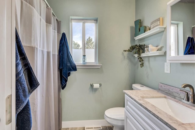 bathroom featuring visible vents, toilet, a shower with shower curtain, baseboards, and vanity