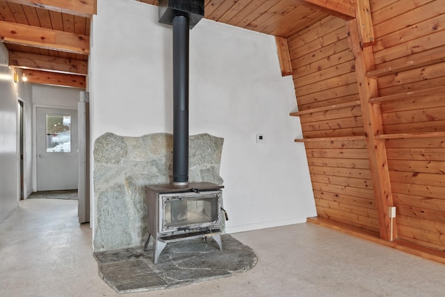 unfurnished living room featuring wood ceiling, wood walls, and a wood stove