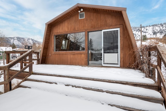 snow covered property entrance featuring a mountain view