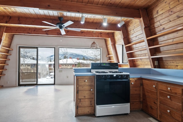 kitchen featuring wood walls, wood ceiling, gas stove, ceiling fan, and beamed ceiling