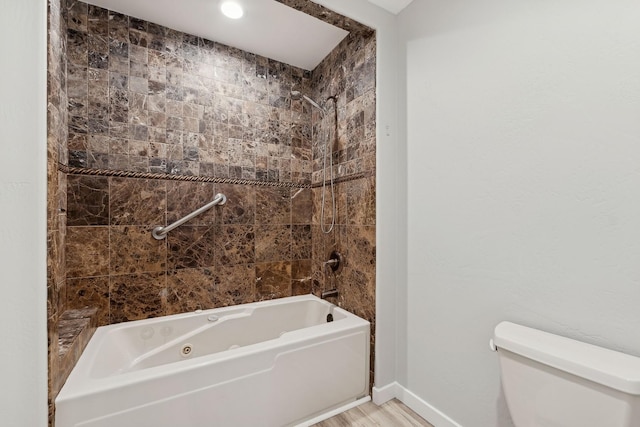 bathroom featuring toilet, tiled shower / bath combo, and hardwood / wood-style flooring