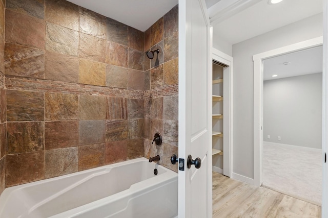 bathroom with wood-type flooring and tiled shower / bath combo