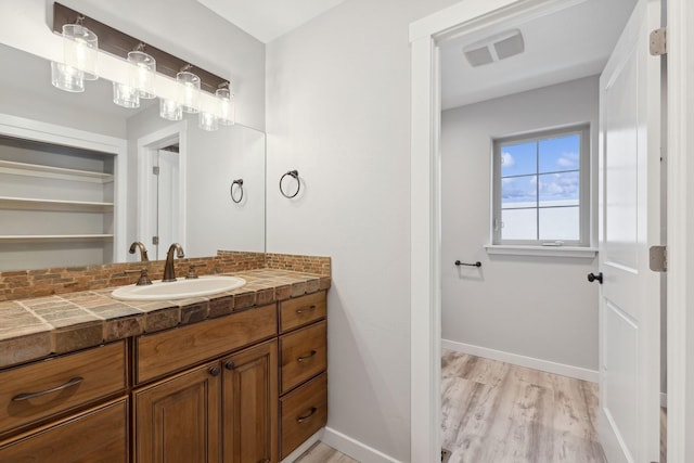 bathroom with vanity, decorative backsplash, and hardwood / wood-style floors