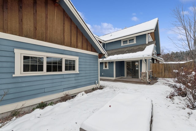 view of snow covered back of property