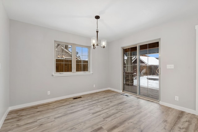 unfurnished dining area with light hardwood / wood-style flooring and a chandelier