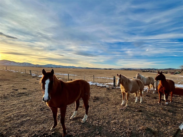 view of horse barn featuring a rural view and a mountain view