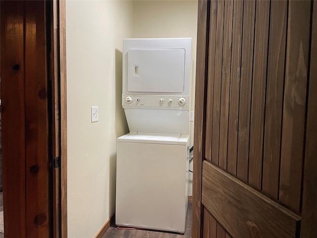 laundry area with stacked washer and dryer and hardwood / wood-style floors