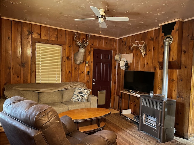 living room with ceiling fan, ornamental molding, wooden walls, and hardwood / wood-style flooring