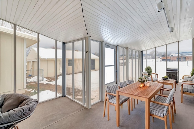 sunroom / solarium with a water view and a wood stove