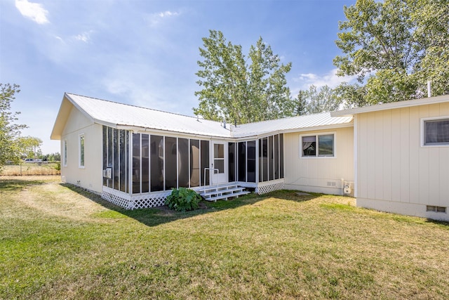 rear view of property with a lawn and a sunroom