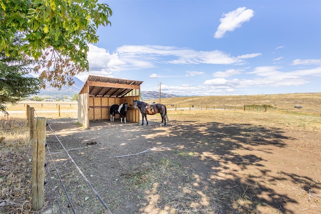 view of horse barn featuring a rural view