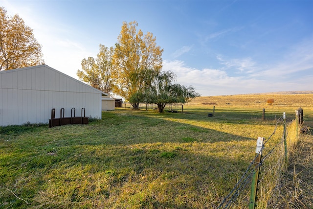 view of yard featuring a rural view and an outdoor structure