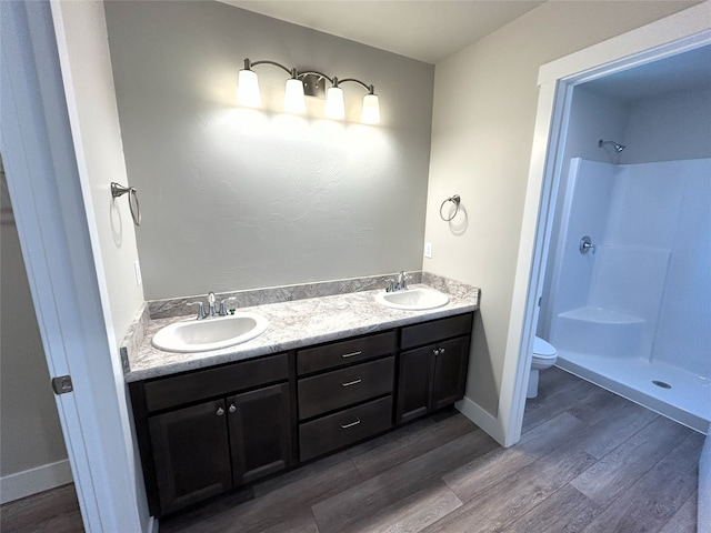 bathroom featuring a shower, toilet, vanity, and hardwood / wood-style flooring