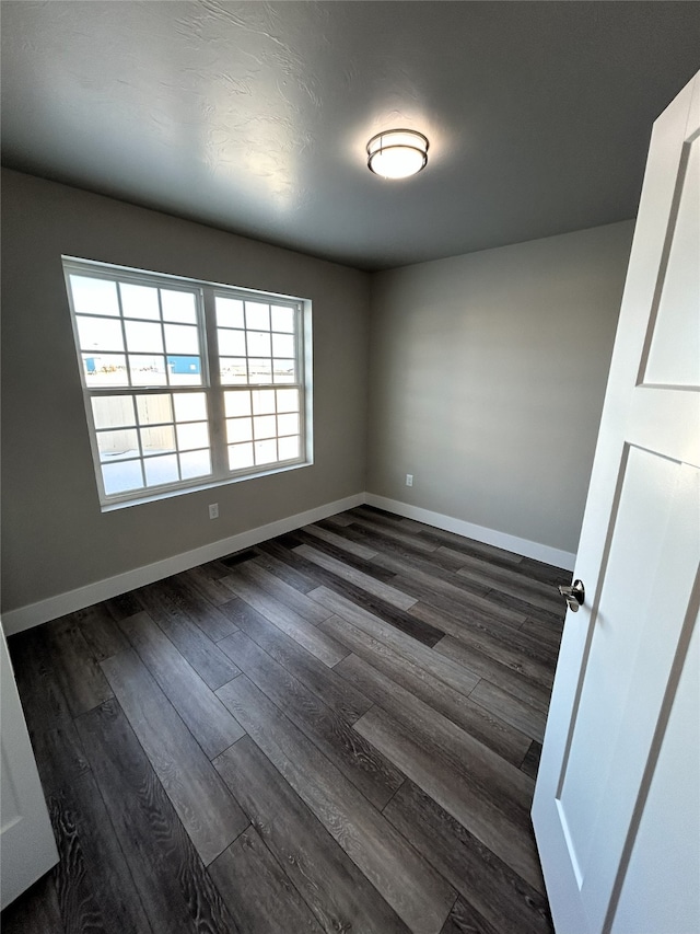 empty room with dark hardwood / wood-style flooring