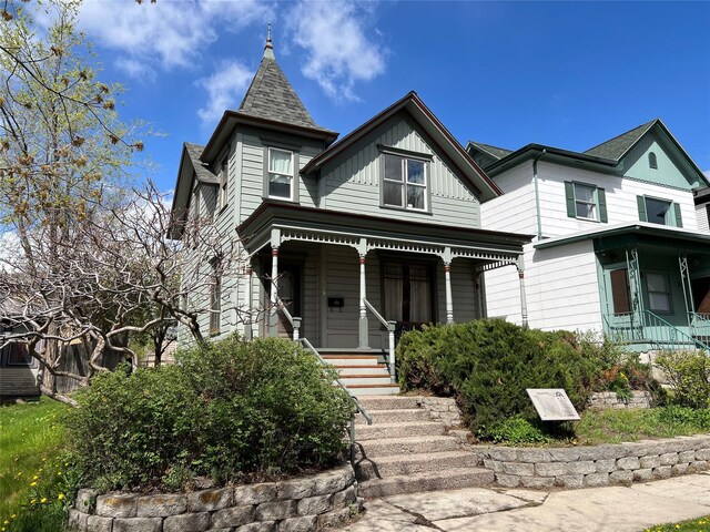 victorian house with covered porch and board and batten siding