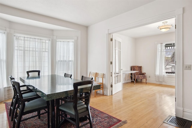 dining area with a wealth of natural light and light hardwood / wood-style floors