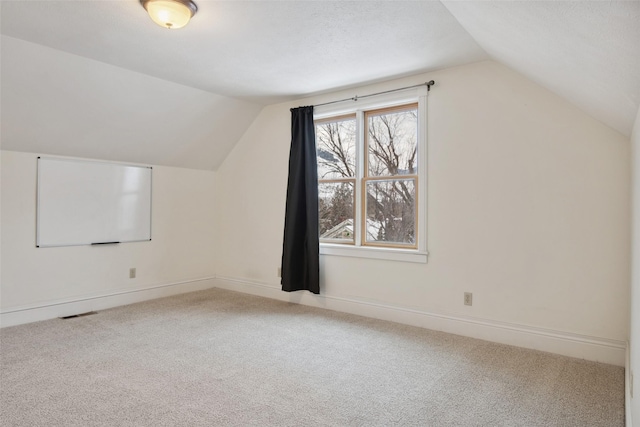 additional living space featuring vaulted ceiling and carpet