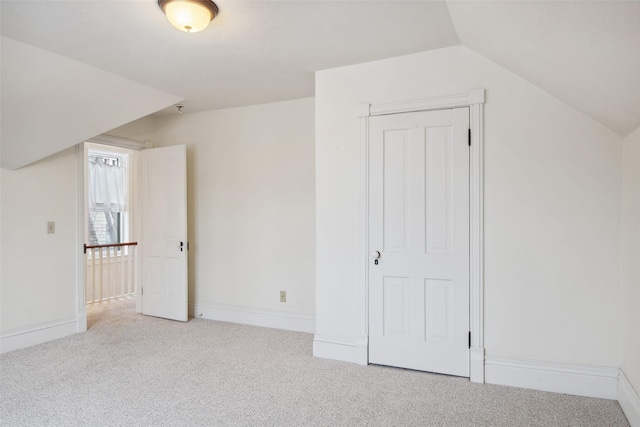 additional living space with light colored carpet and lofted ceiling