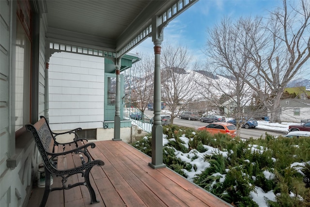 snow covered deck featuring covered porch and a mountain view