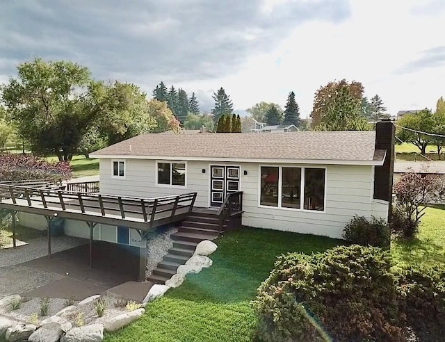 back of property featuring a yard and a wooden deck