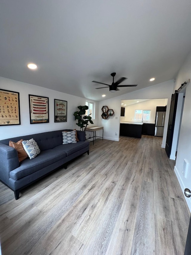 living room with vaulted ceiling, hardwood / wood-style flooring, and ceiling fan