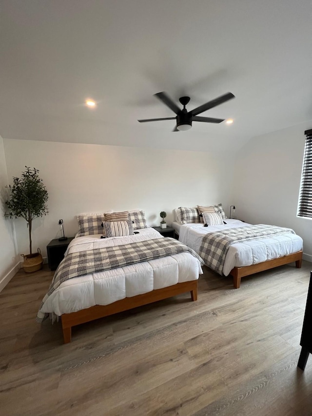 bedroom featuring ceiling fan, vaulted ceiling, and wood-type flooring