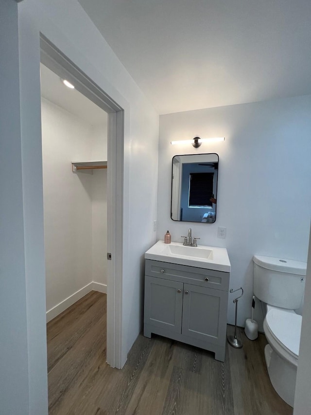 bathroom with toilet, vanity, and hardwood / wood-style floors