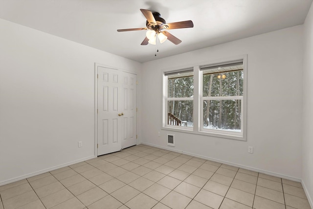 tiled empty room with ceiling fan