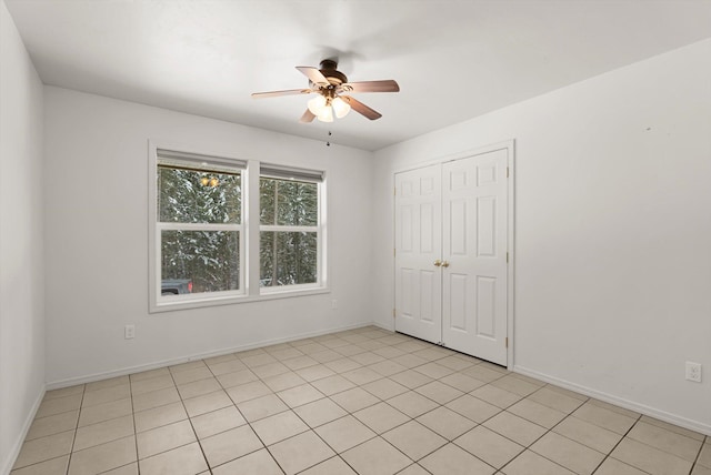 tiled spare room with ceiling fan