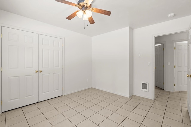 unfurnished bedroom featuring light tile patterned flooring, a closet, and ceiling fan