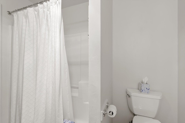 bathroom with toilet and a shower with curtain