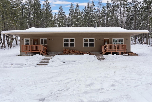 snow covered back of property with covered porch