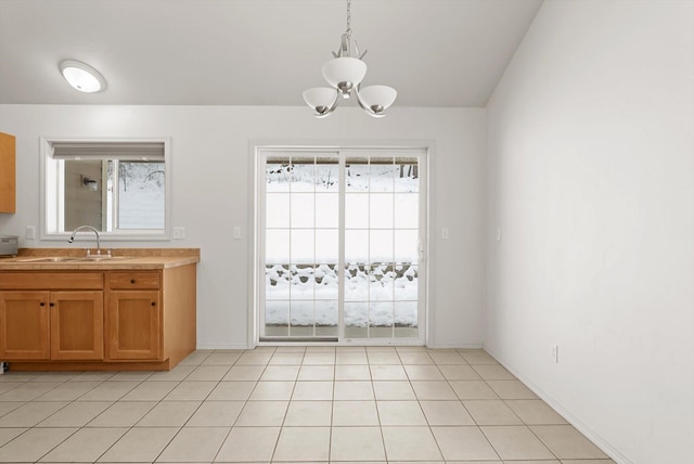 unfurnished dining area featuring sink, a chandelier, and light tile patterned floors