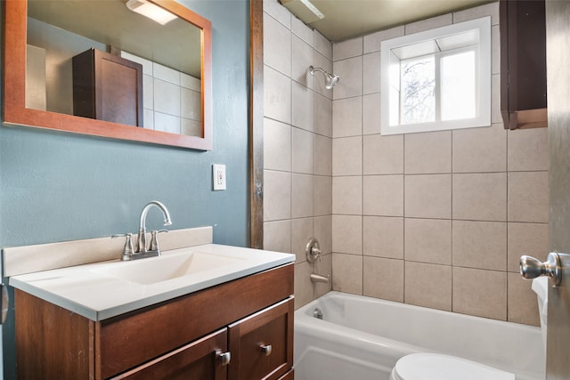 full bathroom with toilet, tiled shower / bath combo, and vanity