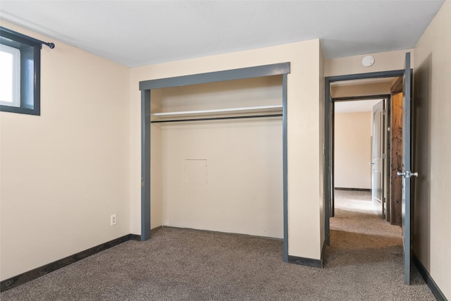 unfurnished bedroom featuring a closet and dark colored carpet