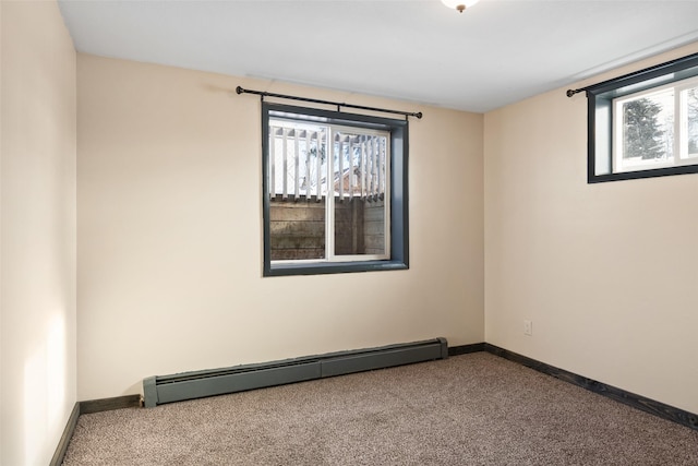 spare room featuring a baseboard heating unit and carpet floors