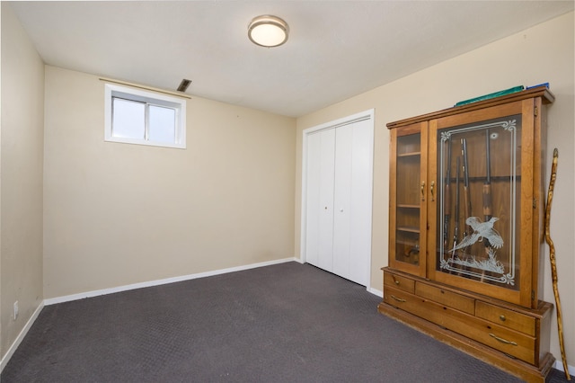 unfurnished bedroom featuring a closet and dark carpet