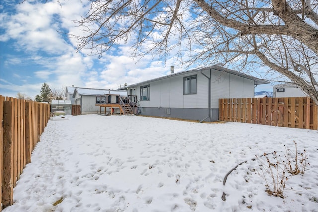 snow covered property with a wooden deck