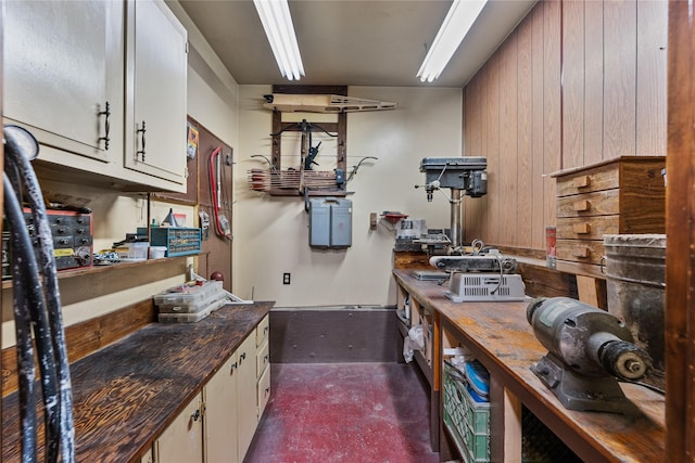 kitchen with wooden walls and white cabinetry