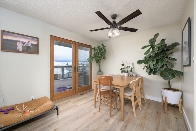 dining space with a textured ceiling, ceiling fan, french doors, and light hardwood / wood-style floors