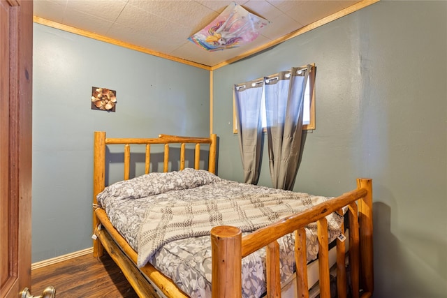 bedroom with ornamental molding and dark hardwood / wood-style floors