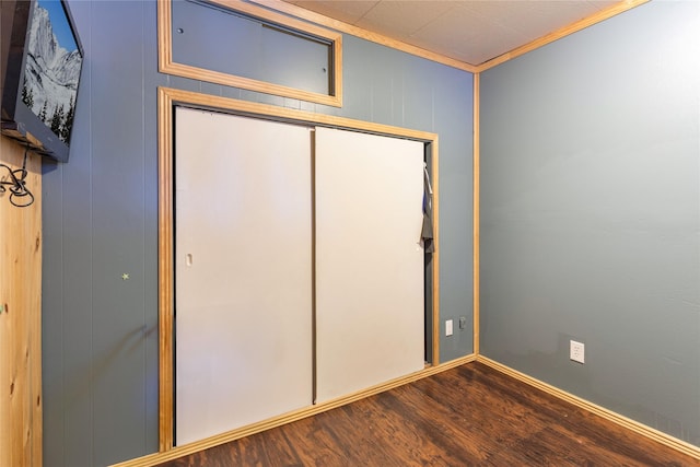 unfurnished bedroom with a closet, crown molding, and wood-type flooring