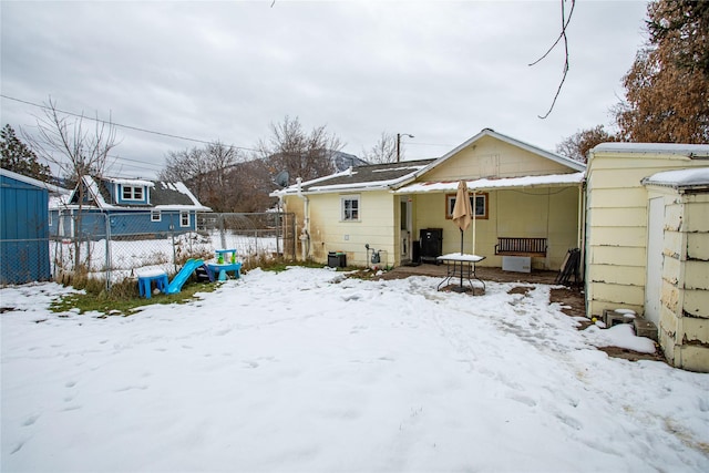 view of snow covered back of property